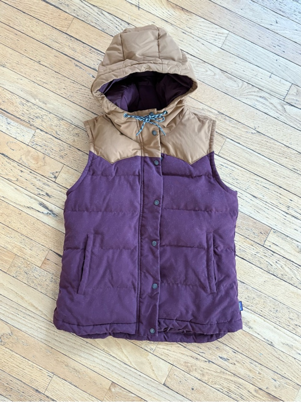 Patagonia Hooded vest.  Stain on inside lining,  and tiny spot on bottom hem.